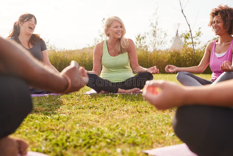 Group Of Mature Men And Women In Class At Outdoor Yoga Retreat Sitting Circle Meditating. Group Of Mature Men And Women In Class At Outdoor Yoga Retreat Sitting Circle Meditating