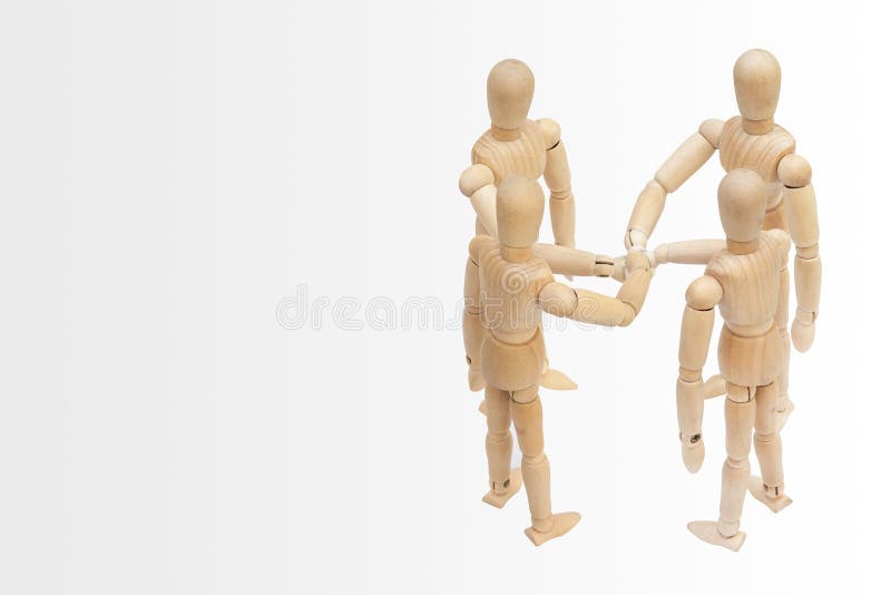 Grupa drewniana postaci mannequin kładzenia sterta ich ręki wpólnie obrazy stock Grupa drewniana postaci mannequin kładzenia sterta ich ręki wpólnie obrazy stock