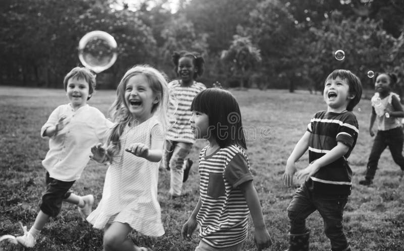 Group of kindergarten kids friends playing blowing bubbles fun. Group of kindergarten kids friends playing blowing bubbles fun