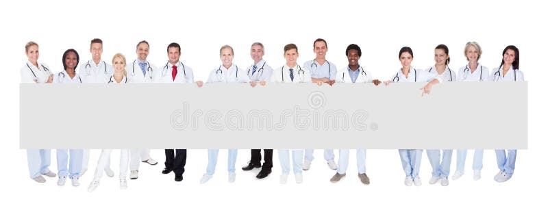 Group Of Smiling Doctors With Placard Over White Background. Group Of Smiling Doctors With Placard Over White Background