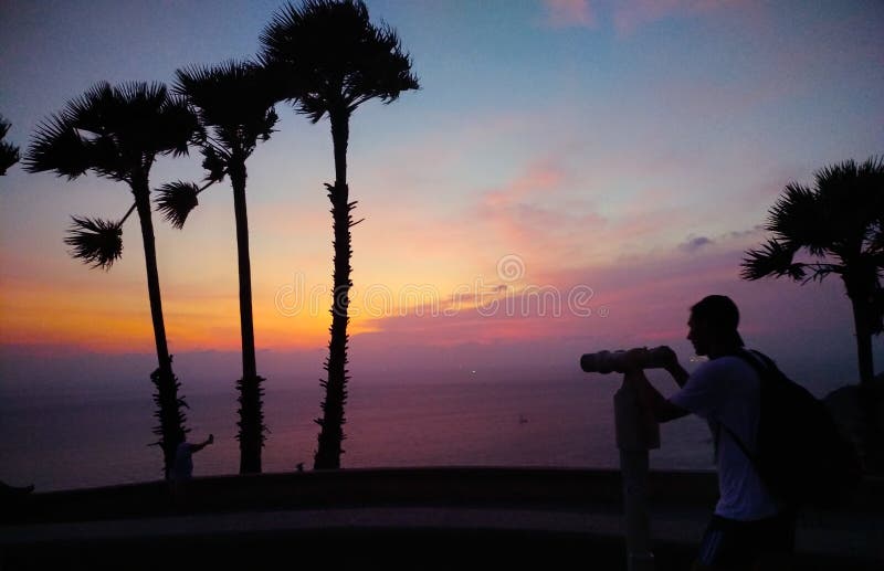 Grupa ludzi bierze fotografię przy plażą na zmierzchu fotografia stock Grupa ludzi bierze fotografię przy plażą na zmierzchu fotografia stock
