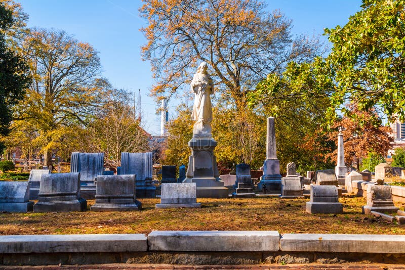 Group of tombstones and sculpture of Virgin Mary on the Oakland Cemetery in sunny autumn day, Atlanta, USA. Group of tombstones and sculpture of Virgin Mary on the Oakland Cemetery in sunny autumn day, Atlanta, USA