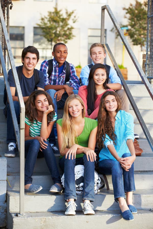 Group Of Teenage Pupils Outside Classroom Smiling To Camera Sitting On Steps. Group Of Teenage Pupils Outside Classroom Smiling To Camera Sitting On Steps