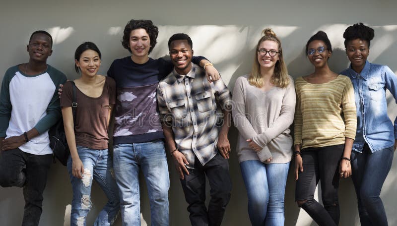 Group of diverse teenager standing smiling by the wall. Group of diverse teenager standing smiling by the wall