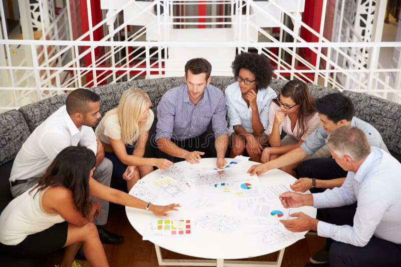 Group of work colleagues having meeting in an office lobby. Group of work colleagues having meeting in an office lobby