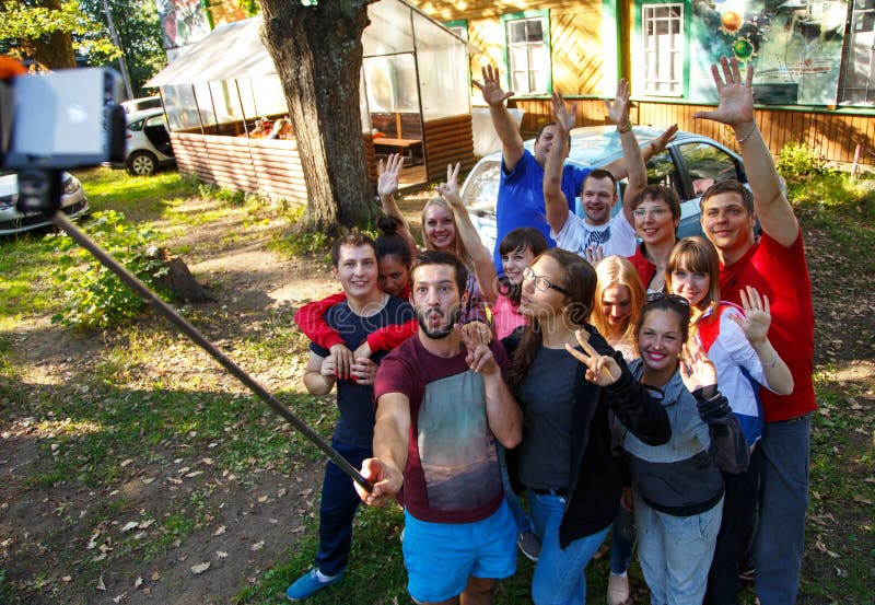 Grupa przyjaciele bierze selfie z selfie kijem outdoors obraz stock Grupa przyjaciele bierze selfie z selfie kijem outdoors obraz stock