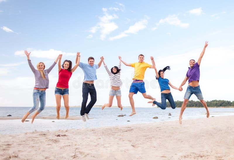 Summer, holidays, vacation, happy people concept - group of friends jumping on the beach. Summer, holidays, vacation, happy people concept - group of friends jumping on the beach