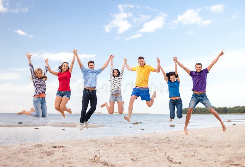 Summer, holidays, vacation, happy people concept - group of friends jumping on the beach. Summer, holidays, vacation, happy people concept - group of friends jumping on the beach