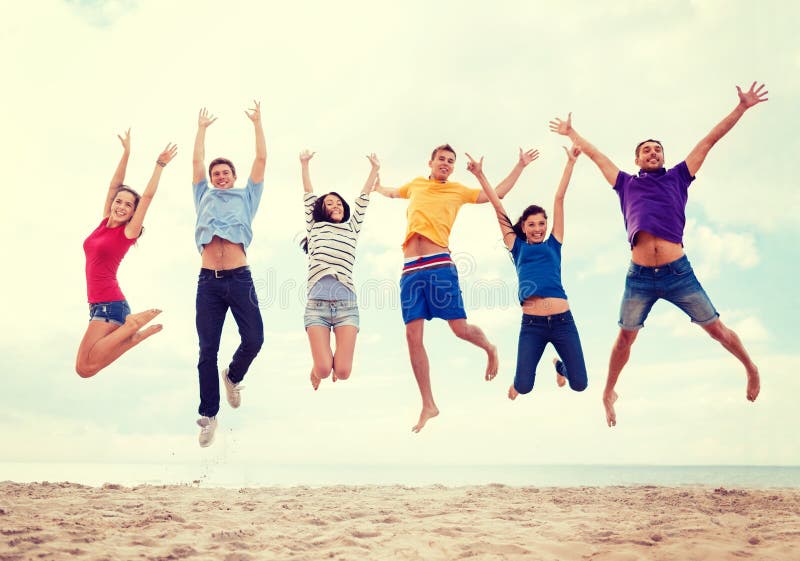 Summer, holidays, vacation, happy people concept - group of friends jumping on the beach. Summer, holidays, vacation, happy people concept - group of friends jumping on the beach