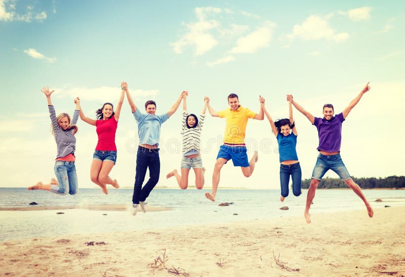 Summer, holidays, vacation, happy people concept - group of friends jumping on the beach. Summer, holidays, vacation, happy people concept - group of friends jumping on the beach