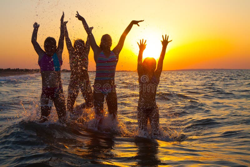 Group of happy young girls jumping at the beach on beautiful summer sunset. Group of happy young girls jumping at the beach on beautiful summer sunset