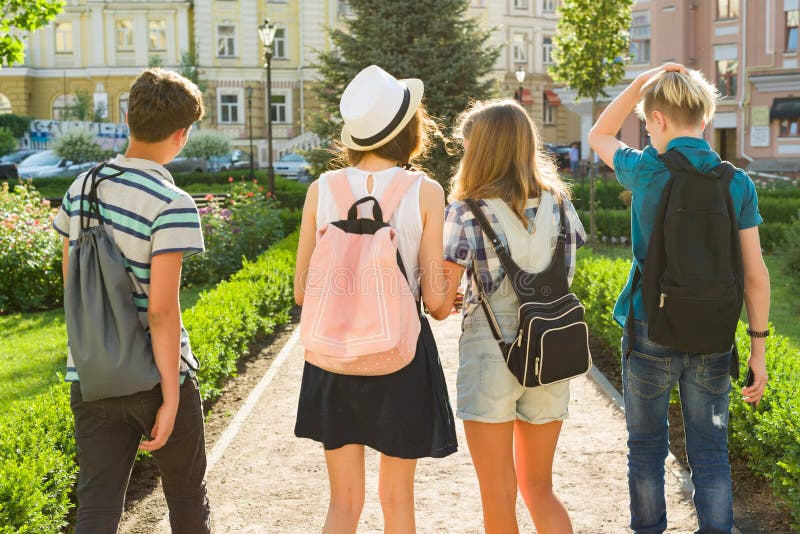 Grupa szczęśliwi nastolatków przyjaciele 13, 14 roku chodzi wzdłuż miasto ulicy widok z powrotem obraz stock Grupa szczęśliwi nastolatków przyjaciele 13, 14 roku chodzi wzdłuż miasto ulicy widok z powrotem obraz stock