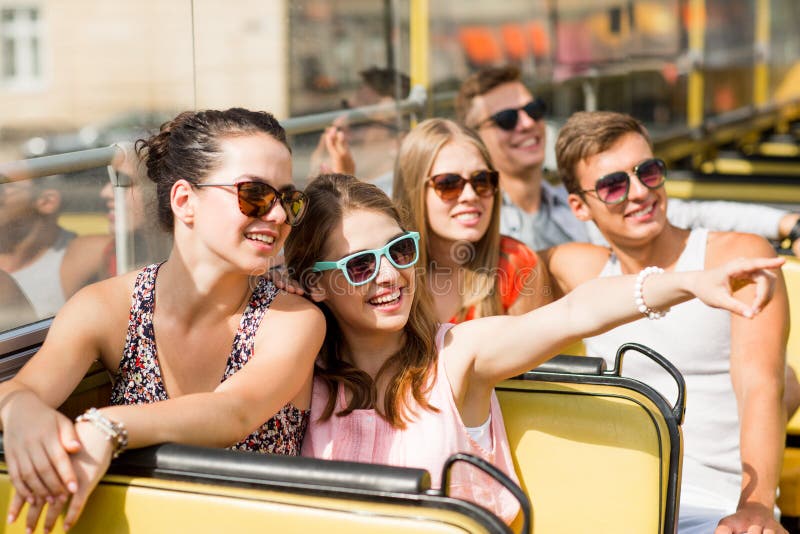 Grupa uśmiechnięci przyjaciele podróżuje wycieczką autobusową obrazy stock