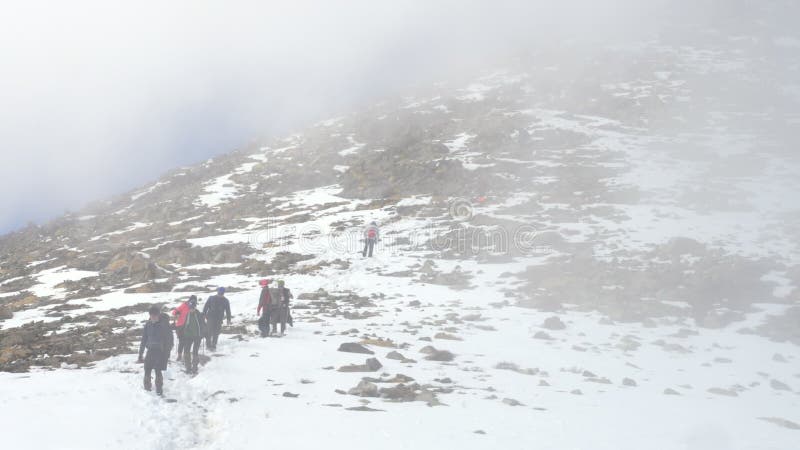Grupa wspinaczy opuszczających góry zimą Ciemno