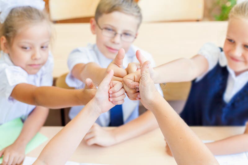 Grupo bem sucedido de crianças na escola com o polegar acima do gesto imagem de stock royalty free Grupo bem sucedido de crianças na escola com o polegar acima do gesto imagem de stock royalty free