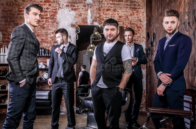 Grupo de actitud para hombre positiva elegante joven en el interior de la barbería foto de archivo libre de regalías Grupo de actitud para hombre positiva elegante joven en el interior de la barbería foto de archivo libre de regalías