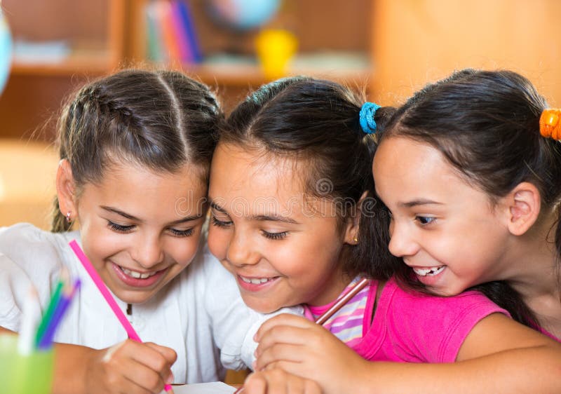 Grupo de alunos bonitos que têm o divertimento na sala de aula fotos de stock Grupo de alunos bonitos que têm o divertimento na sala de aula fotos de stock