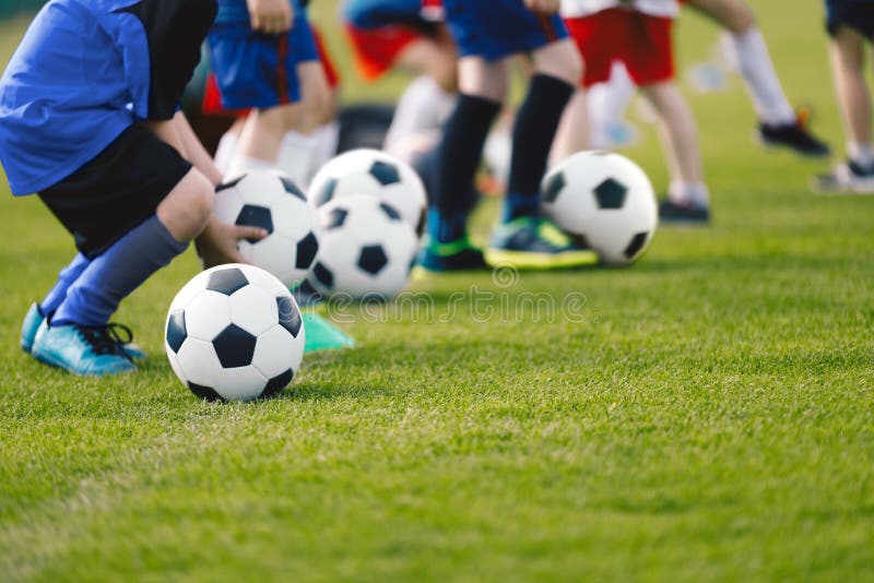 Dois Jogadores De Futebol Chutando Bola De Futebol Em Um Jogo. Meninos Da  Escola Jogam Competição Esportiva. Duas Crianças Multirraciais Jogando  Partida De Futebol. Crianças Em Uniformes De Futebol Verde E Azul