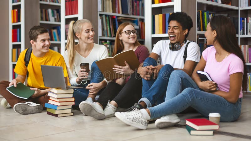 Grupo de amigos adolescentes riendo mientras se preparaban para los exámenes fotos de archivo libres de regalías Grupo de amigos adolescentes riendo mientras se preparaban para los exámenes fotos de archivo libres de regalías