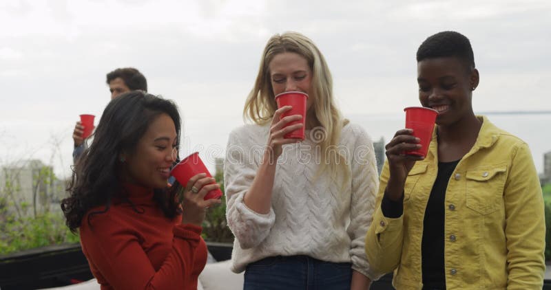 Grupo de amigos bebiendo una cerveza en la azotea almacen de metraje de vídeo