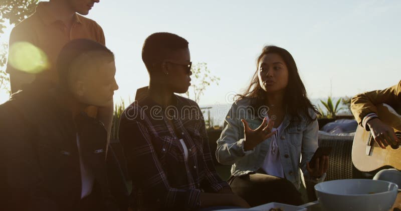 Grupo de amigos discutiendo en una azotea almacen de metraje de vídeo