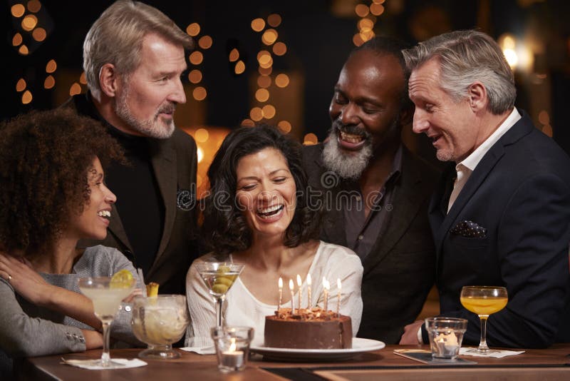 Grupo de amigos envelhecidos meio que comemoram o aniversário na barra