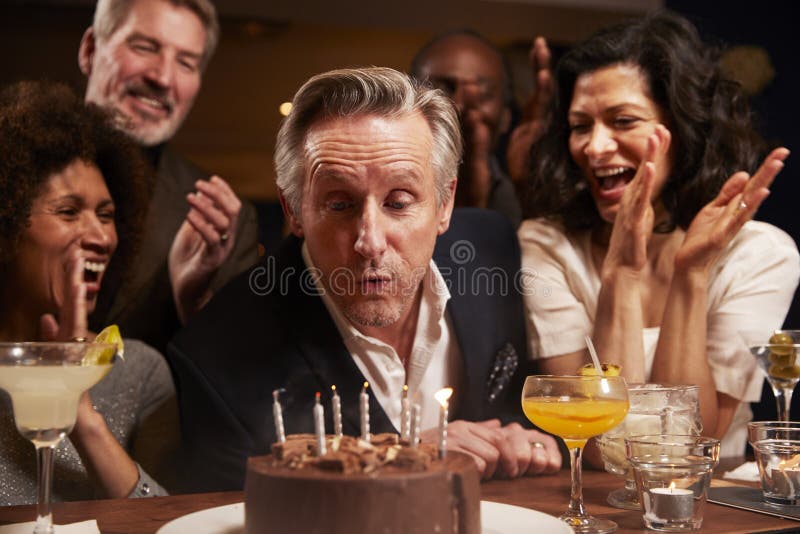 Grupo de amigos envelhecidos meio que comemoram o aniversário na barra