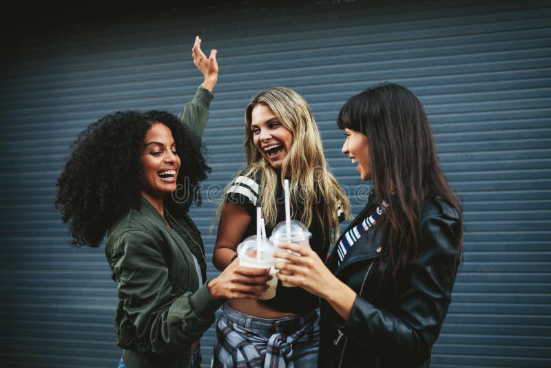 Grupo de amigos fêmeas que têm o divertimento com café de gelo imagens de stock Grupo de amigos fêmeas que têm o divertimento com café de gelo imagens de stock