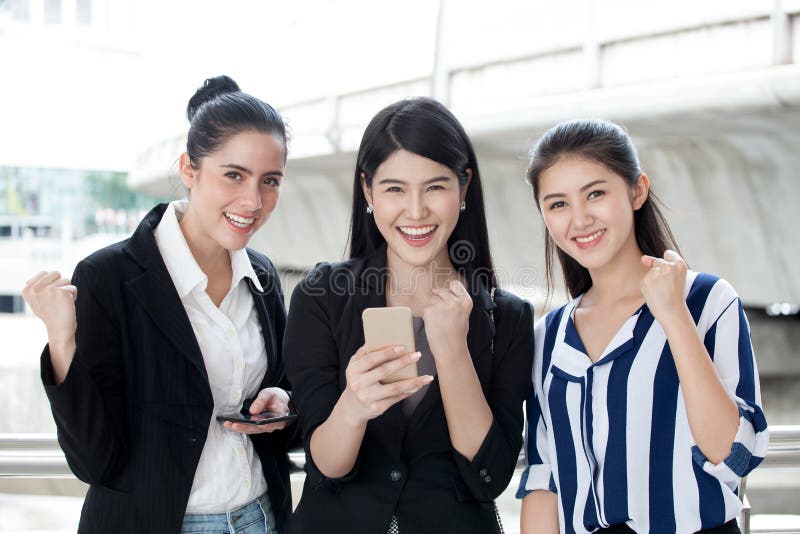 grupo de amigos hermosos de las mujeres jovenes que usan un teléfono y una risa elegantes negocio emocionante de tres muchachas e fotos de archivo grupo de amigos hermosos de las mujeres jovenes que usan un teléfono y una risa elegantes negocio emocionante de tres muchachas e fotos de archivo