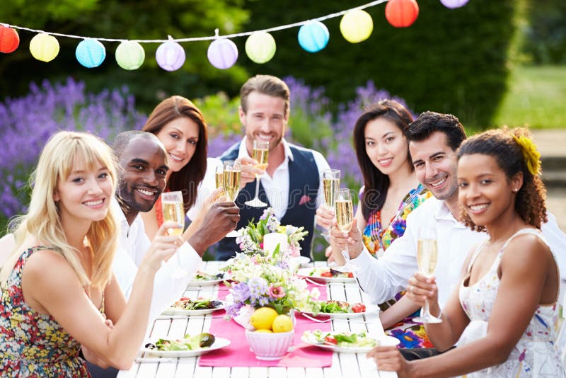 Group Of Friends Enjoying Outdoor Dinner Party Holding Glass Of Champagne Smiling To Camera. Group Of Friends Enjoying Outdoor Dinner Party Holding Glass Of Champagne Smiling To Camera