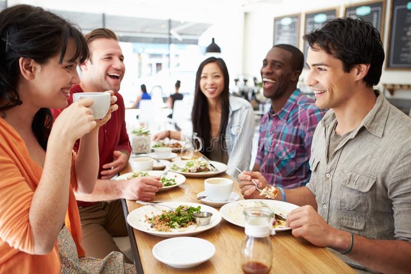 Group Of Friends Meeting For Lunch In Coffee Shop and all Smiling. Group Of Friends Meeting For Lunch In Coffee Shop and all Smiling