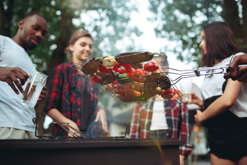 Grupo de amigos que hacen la barbacoa en el patio trasero concepto sobre humor bueno y positivo con los amigos imagenes de archivo Grupo de amigos que hacen la barbacoa en el patio trasero concepto sobre humor bueno y positivo con los amigos imagenes de archivo