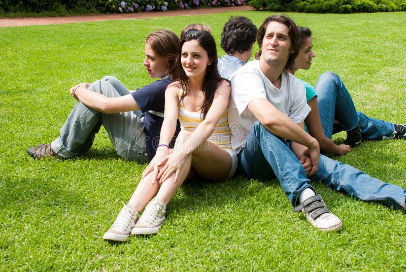 Grupo de amigos que sorriem ao ar livre em um parque imagens de stock royalty free Grupo de amigos que sorriem ao ar livre em um parque imagens de stock royalty free