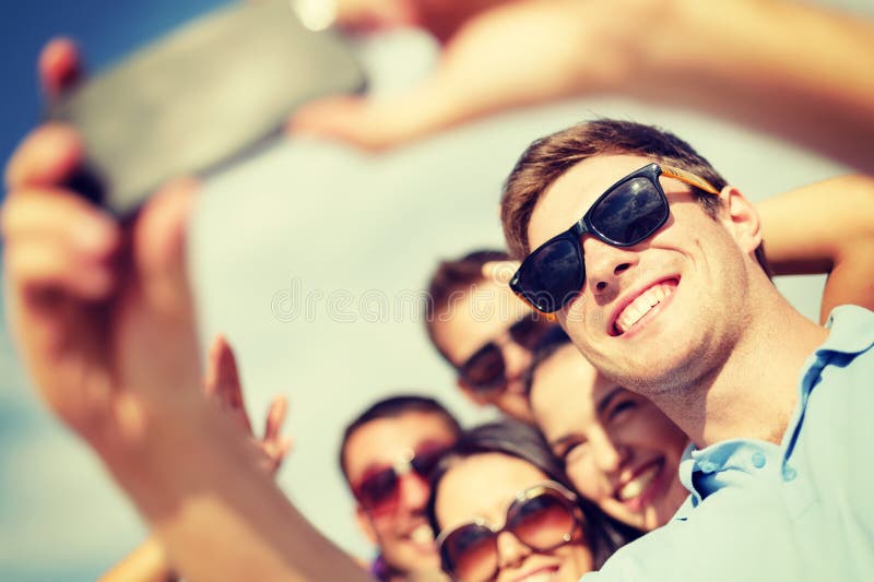 Grupo de amigos que toman la imagen con smartphone foto de archivo libre de regalías Grupo de amigos que toman la imagen con smartphone foto de archivo libre de regalías