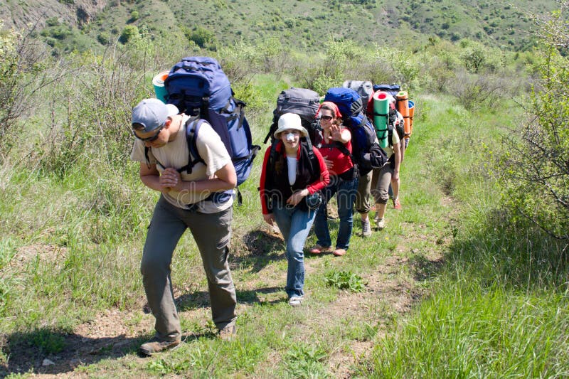 Grupo de backpacker que se levanta en la montaña