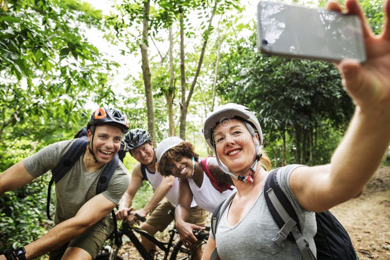 Grupo de ciclistas diversos en el bosque que toma la imagen imagen de archivo Grupo de ciclistas diversos en el bosque que toma la imagen imagen de archivo