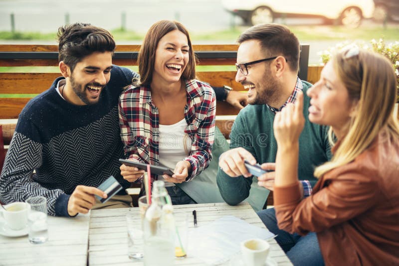 Grupo de cuatro amigos que se divierten un café junto imagen de archivo libre de regalías Grupo de cuatro amigos que se divierten un café junto imagen de archivo libre de regalías