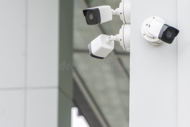 Outdoor CCTV security cameras installed on the modern white building wall in the city. Concept of surveillance and monitoring. Outdoor CCTV security cameras installed on the modern white building wall in the city. Concept of surveillance and monitoring.