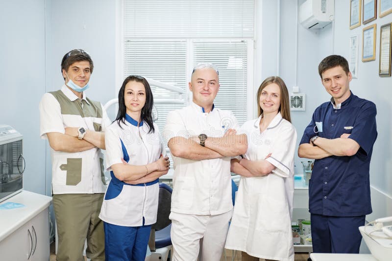 A group of dentists in uniform, men and women team, in the office of the dental clinic. A group of dentists in uniform, men and women team, in the office of the dental clinic