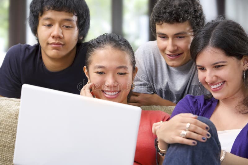 Grupo de estudante que presta atenção ao portátil