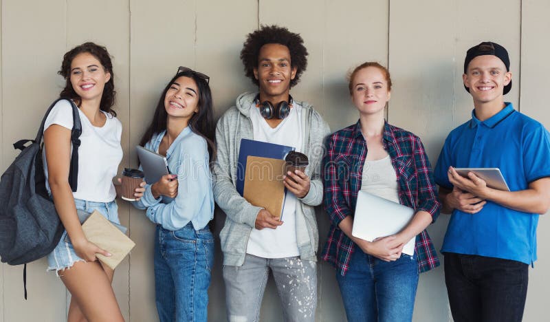 Grupo de estudantes adolescentes ?tnicos com dobradores e sacos de escola imagens de stock Grupo de estudantes adolescentes ?tnicos com dobradores e sacos de escola imagens de stock