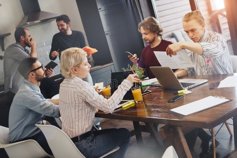 Grupo de estudantes criativos que discutem e que encontram-se na cozinha te imagens de stock royalty free Grupo de estudantes criativos que discutem e que encontram-se na cozinha te imagens de stock royalty free