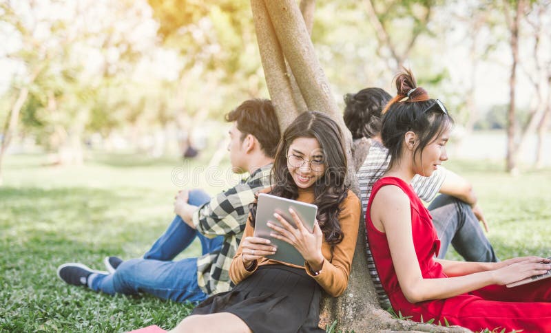 Grupo de estudantes ou de adolescentes com o portátil e os tablet pc que penduram para fora imagem de stock Grupo de estudantes ou de adolescentes com o portátil e os tablet pc que penduram para fora imagem de stock