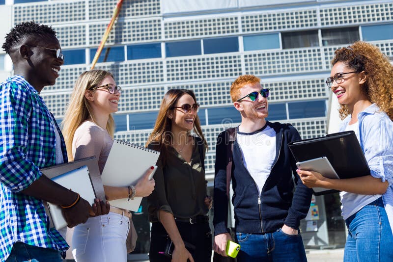 Grupo de estudiantes jovenes felices que hablan en una universidad fotos de archivo libres de regalías Grupo de estudiantes jovenes felices que hablan en una universidad fotos de archivo libres de regalías