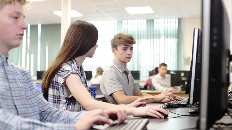 Grupo de estudiantes de la High School secundaria que trabajan junto en clase del ordenador