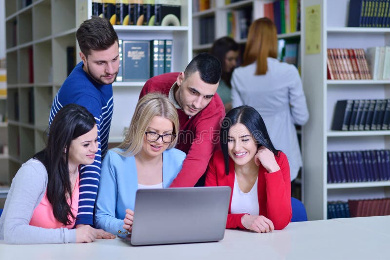 Grupo de estudiantes que trabajan junto en biblioteca con el profesor foto de archivo libre de regalías Grupo de estudiantes que trabajan junto en biblioteca con el profesor foto de archivo libre de regalías