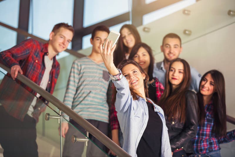 Grupo de estudiantes sonrientes con el smartphone que toma el selfie imagenes de archivo Grupo de estudiantes sonrientes con el smartphone que toma el selfie imagenes de archivo