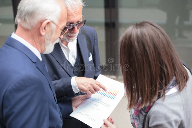 Grupo de executivos misturado pequeno que têm uma reunião, discutindo relatórios de vendas imagem de stock Grupo de executivos misturado pequeno que têm uma reunião, discutindo relatórios de vendas imagem de stock