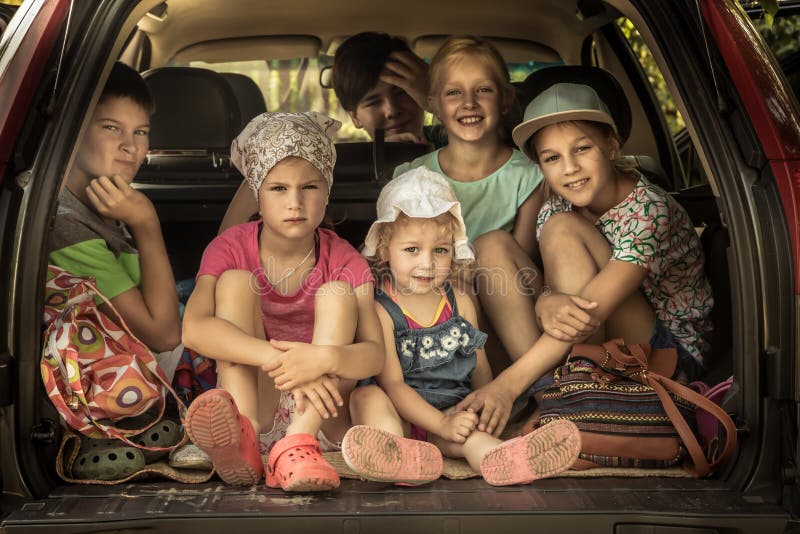 Grupo de família grande de sorriso das crianças na bagagem do tronco de carro que vai à viagem por estrada no carro de família qu fotos de stock royalty free Grupo de família grande de sorriso das crianças na bagagem do tronco de carro que vai à viagem por estrada no carro de família qu fotos de stock royalty free