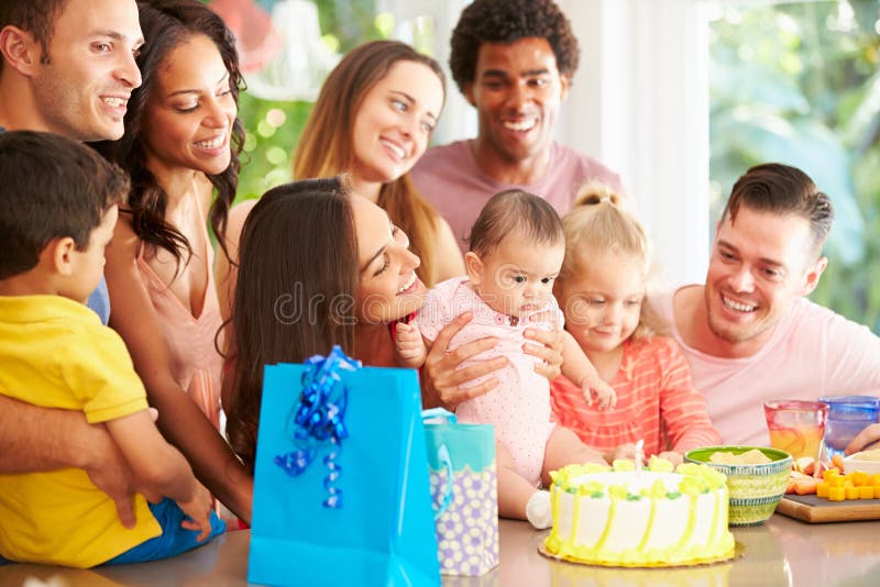 Grupo de famílias que comemoram o primeiro aniversário da criança em casa fotografia de stock Grupo de famílias que comemoram o primeiro aniversário da criança em casa fotografia de stock